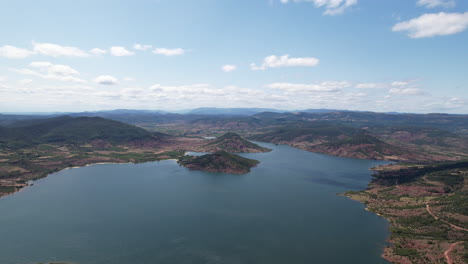 Gran-Toma-Aérea-Sobre-El-Lago-Salagou-Día-Soleado-Montañas-De-Francia-A-Lo-Largo-Del-Gran-Lago