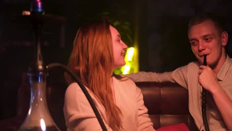 couple relaxing with hookah at night