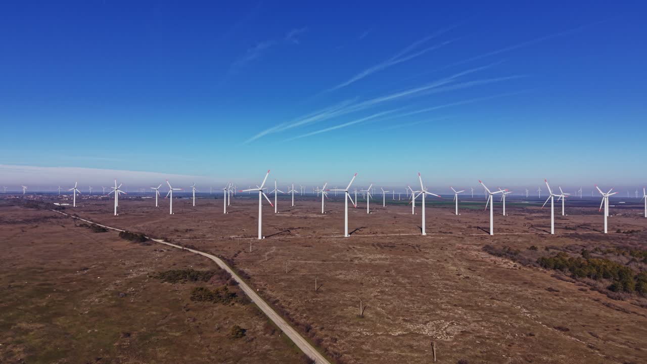 As turbinas eólicas se erguem em uma vasta paisagem em um dia claro