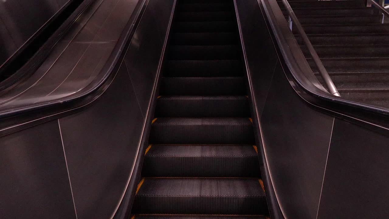 Eskalator Naik di Stasiun Kereta Bawah Tanah yang Sibuk