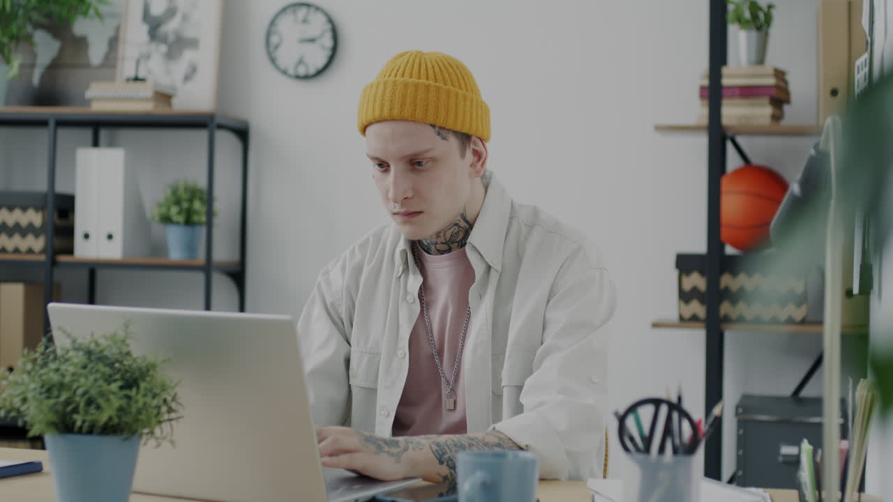 Young man working and celebrating on laptop