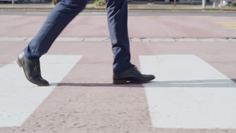 primer plano de pies caminando sobre un cruce público