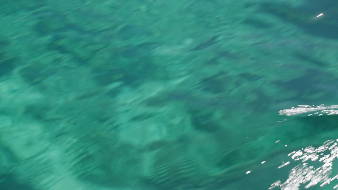 un primer plano en una superficie tranquila de un mar con algunas islas en la parte de atrás en el parque nacional de komodo, indonesia