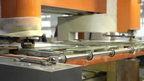 perforar un agujero en el panel de vidrio en una máquina naranja moderna con una mesa móvil