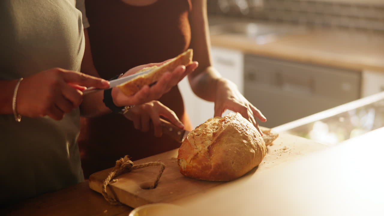 People cutting bread in a kitchen