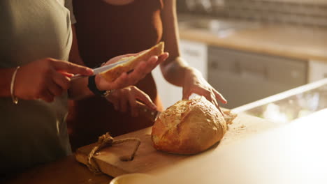 people cutting bread in a kitchen