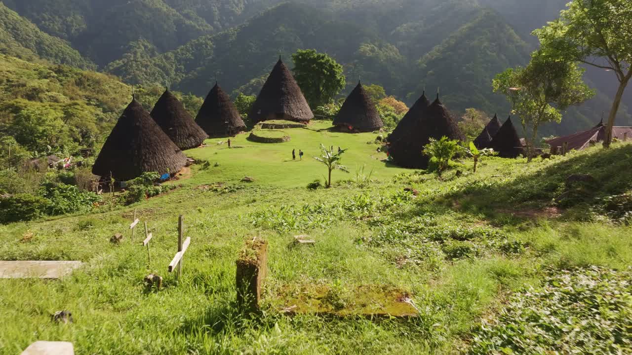 Matahari terbit tropis menyinari desa terpencil di perbukitan Flores.