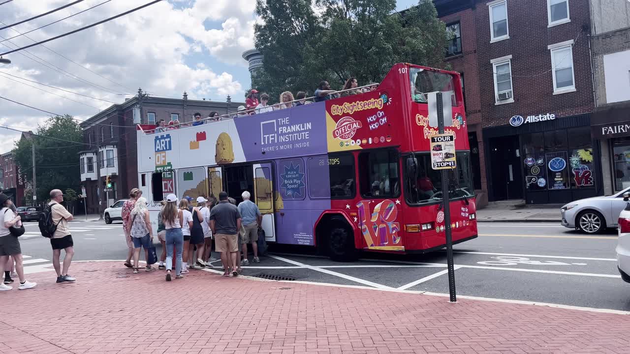 People Boarding a Red Double-Decker City Tour Bus on a Busy Street