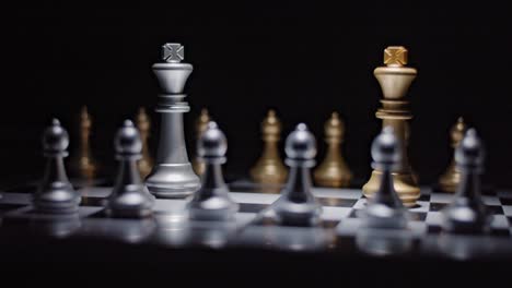 chess match stand-off between silver and gold kings backed by their pawns