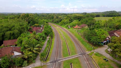 aerial view of railway in the middle of indonesian countryside - drone footage of rural landscape