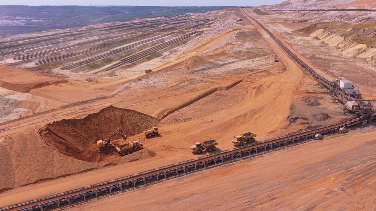 Excavator Loading Dump Trucks in Large Open Pit Mine
