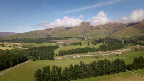 lush foothills of southern alps of new zealand with a highway leading towards the mountains