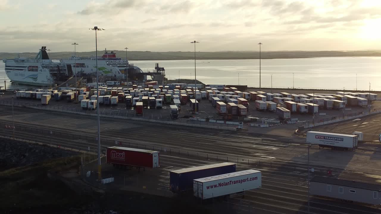 Stena line Holyhead ferry terminal aerial view circling container cargo trucks parking at sunrise