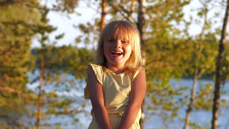 retrato de una joven rubia que muestra auténtica felicidad y pura alegría, fondo del lago al atardecer