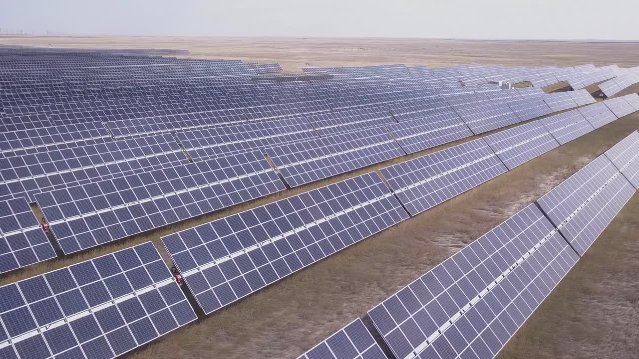 Klar præriehimmel reflekteres i et stort fotovoltaisk solcelleanlæg