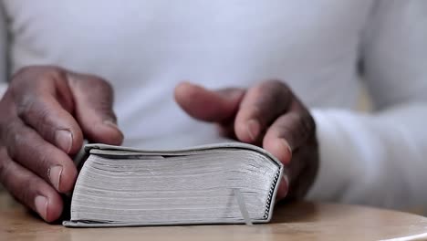 man-praying-to-god-with-hands-together-with-bible-Caribbean-man-praying-with-white-background-stock-footage