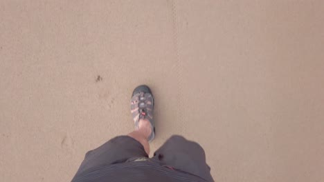 pov of man walking wearing shoe on white sand beach in slow-motion in summer holiday vacation