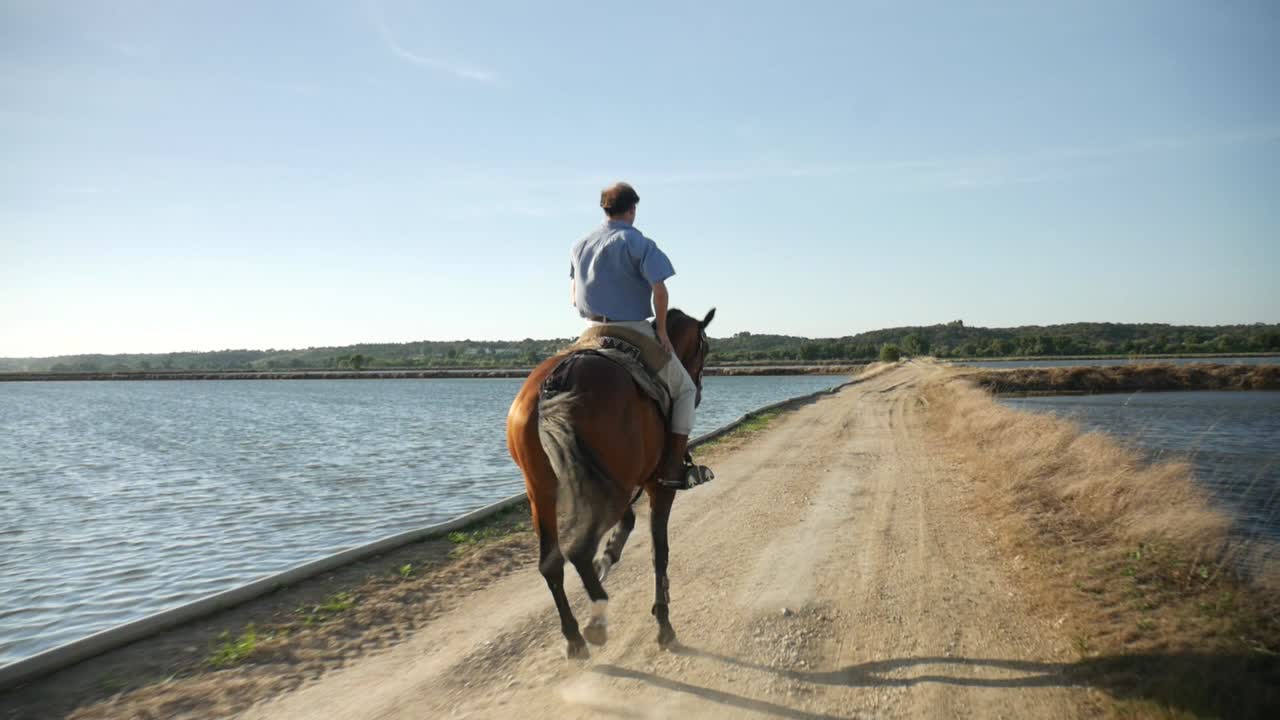 A man riding a horse on a field by the river