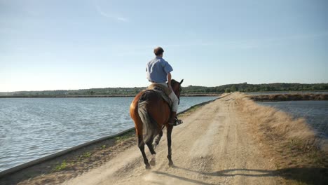 a man riding a horse on a field by the river