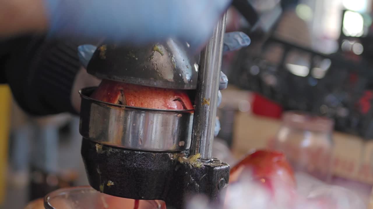 primer plano de una persona exprimiendo jugo de granada