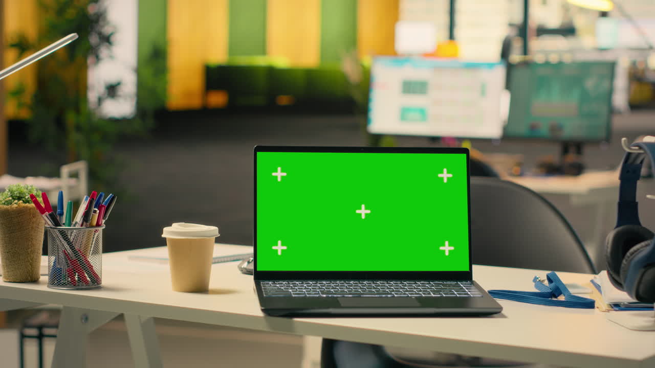 Mockup di schermo verde su laptop su una scrivania aziendale vuota