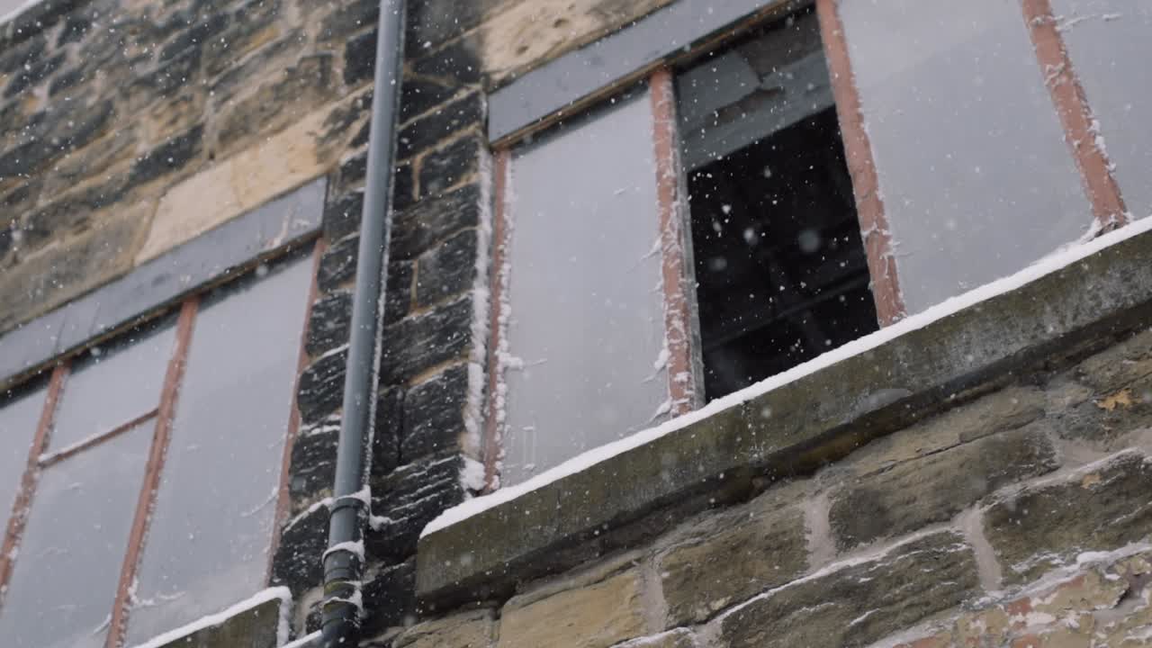 nieve en cámara lenta cayendo sobre un edificio antiguo