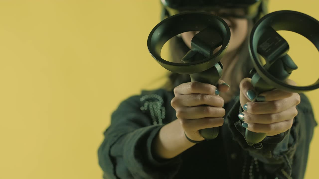 joven jugando con controladores y se pregunta qué tan increíble en el auricular vr. casco de realidad virtual en el fondo amarillo.