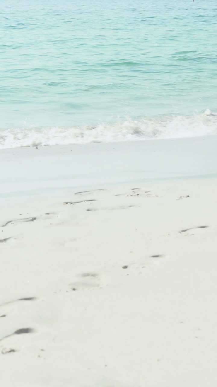 Coppia camminando mano nella mano in spiaggia