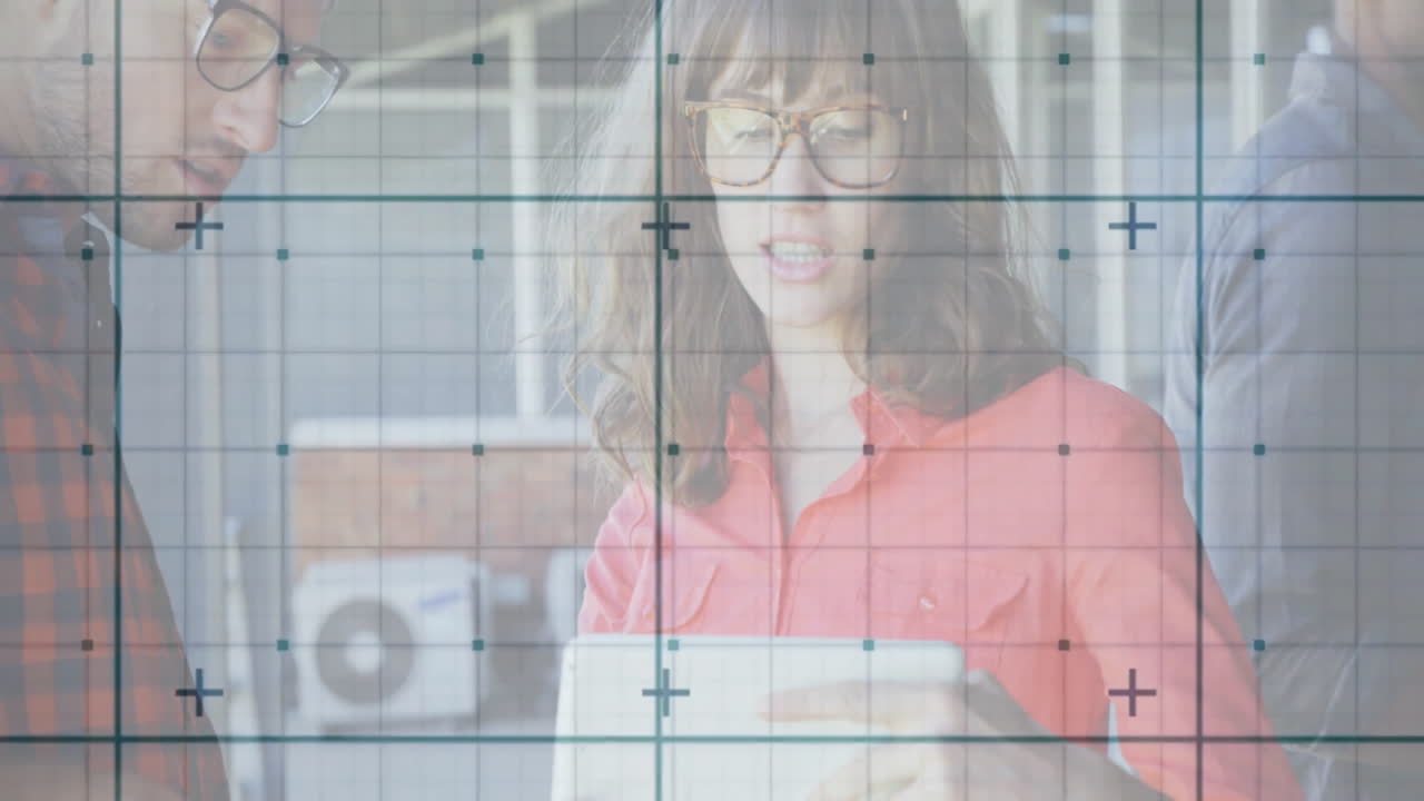 Office professionals holding tablet showing business chart, with floating graph icons