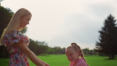 Happy-woman-and-girl-playing-outdoor.-Family-enjoying-sunset-at-meadow.