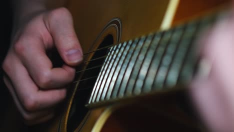 close-up of hands playing an acoustic guitar