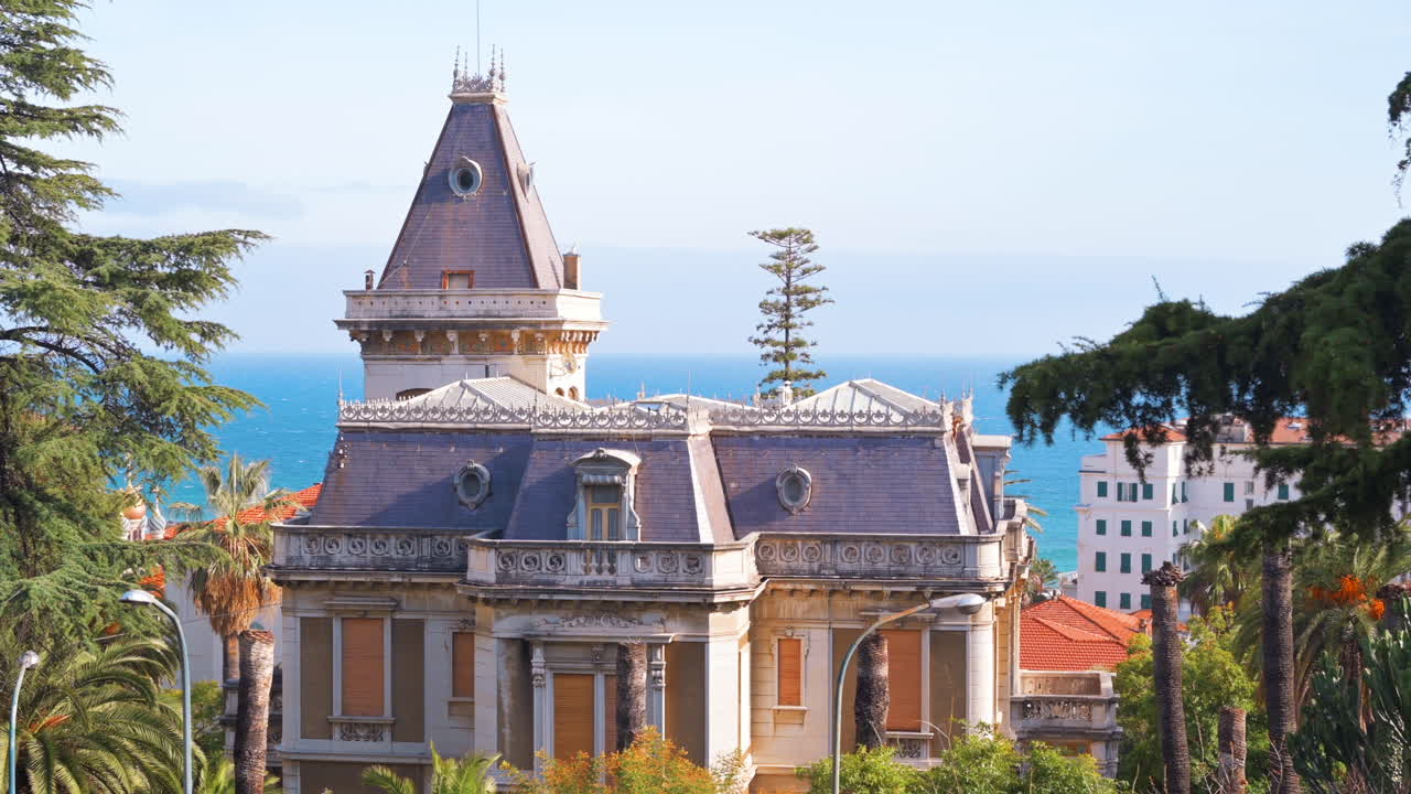 Un’antica dimora in stile classico, costa del Mar Mediterraneo sullo sfondo, vegetazione a Sanremo, Italia