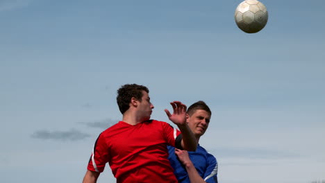 Jugadores-De-Fútbol-Saltando-Y-Atacando-El-Balón.