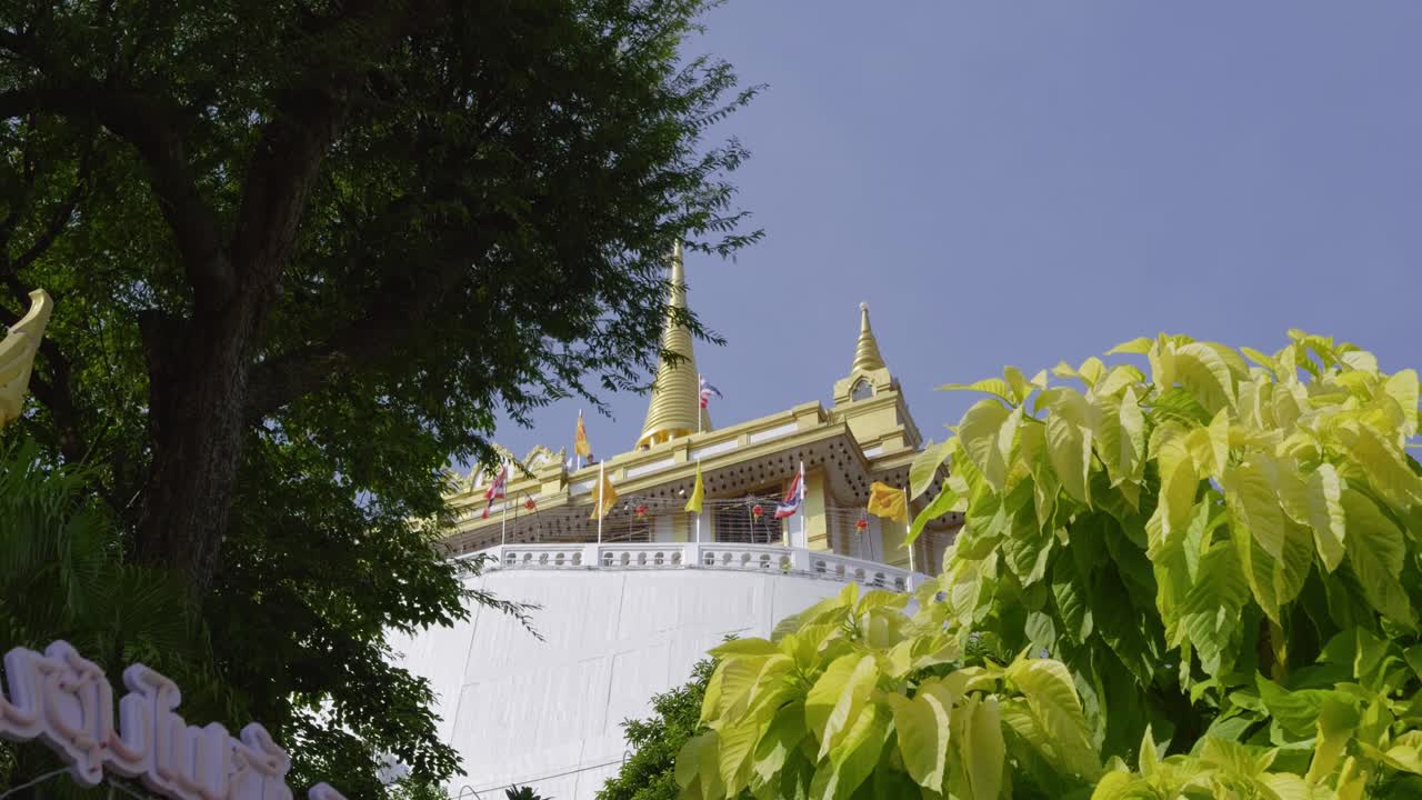 Incredible slider over Golden Mount temple in Thailand with waving flag