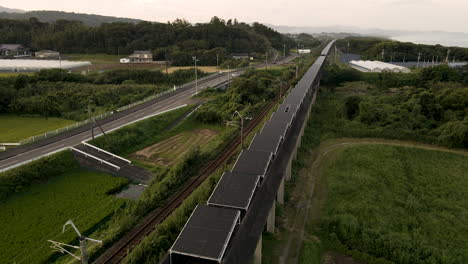 aerial tilting down to solar panels installed on an abandoned monorail track in japan