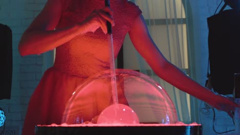 beautiful girl puffs up a big bubble then pierces it with her hand doing a show close-up