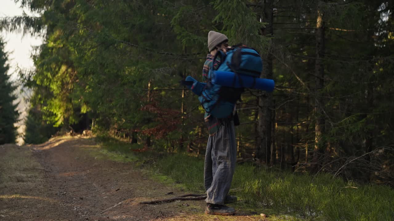 A hiker with a backpack standing in a forest
