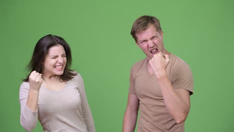 una pareja joven que se ve emocionada y celebra juntos.