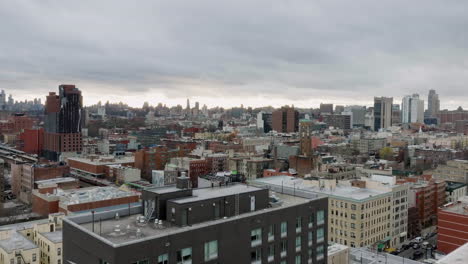 Un-Dron-Disparó-A-Baja-Altura-Sobre-Los-Edificios,-Revelando-Un-Tren,-Una-Tarde-Nublada-En-Upper-Manhattan,-Nueva-York