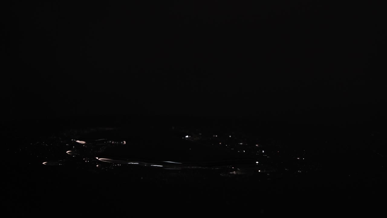 Bok choy falls onto a reflective black surface, creating a dynamic splash effect in slow motion