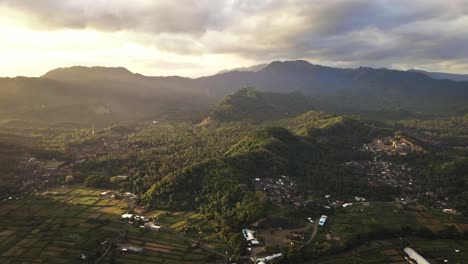 cinematic sunset view of mountain range, tropical forests, rice fields and small villages in karangasem, east bai, indonesia