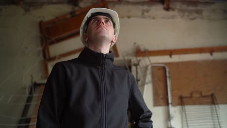 joven arquitecto mirando hacia el techo de una casa vieja para la renovación