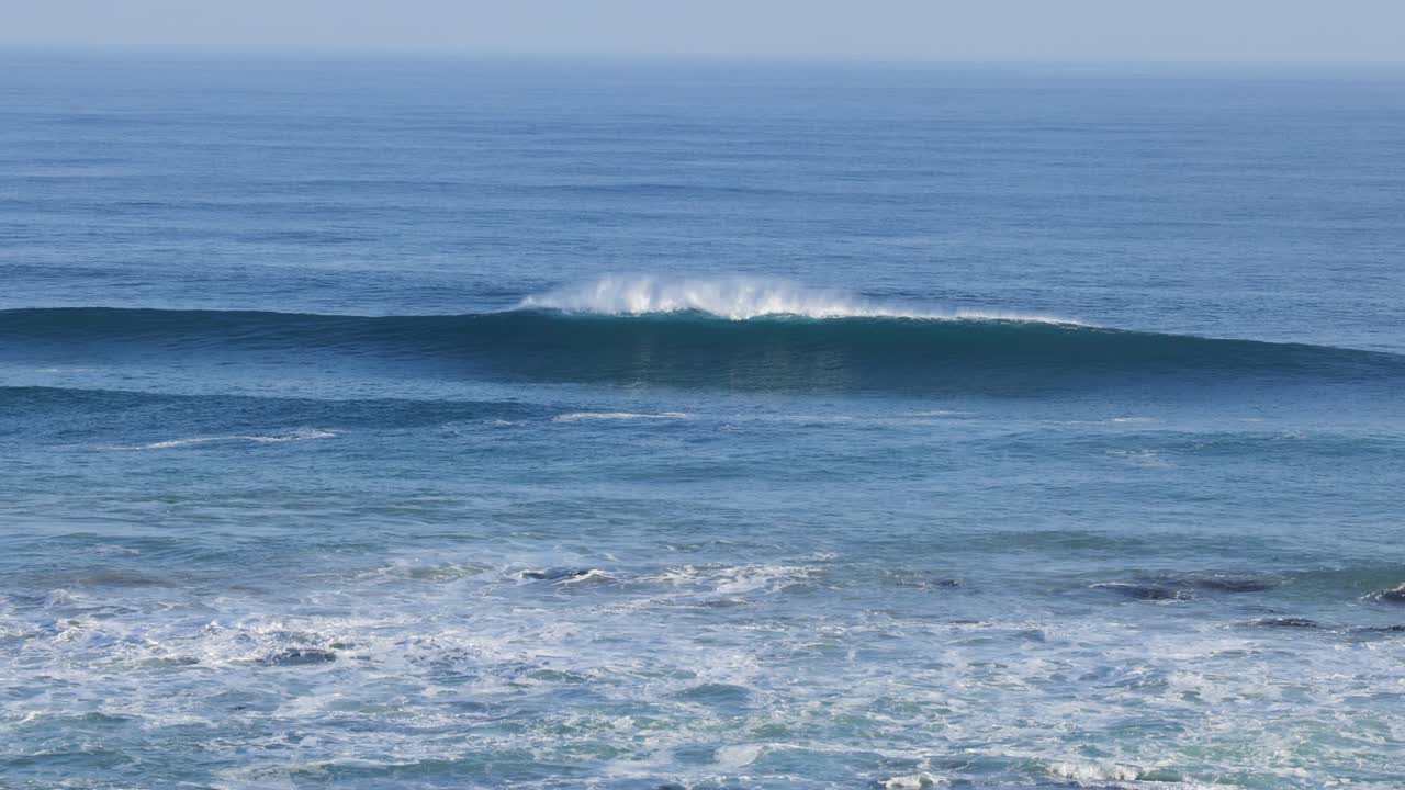 포트 필립 만에서 느리게 움직이는 파도가 부히고 있습니다.