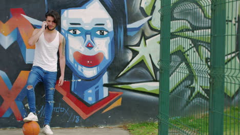 handsome man looking at cellphone with a graffiti as background