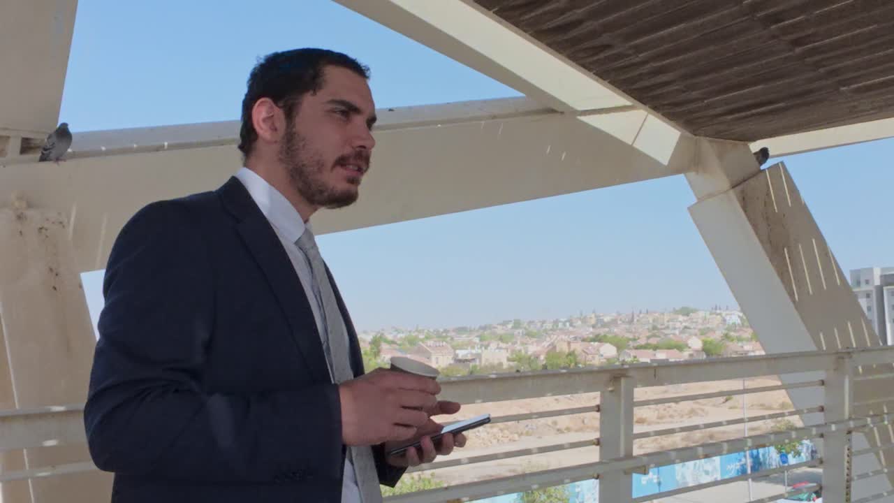 Man in suit with coffee and mobile phone