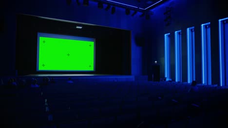 in movie theater captivated audience watching new blockbuster film on mock-up green screen. people watching video game tournament streaming, live concert video, new product release trailer. arc shot