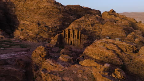 sunset view of monastery ad deir carved out of sandstone rock in petra, jordan