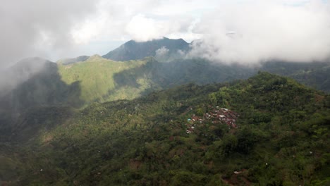 Beautiful-remote-mountain-village-in-Bali-revealed-behind-fog-and-clouds,-Indonesia