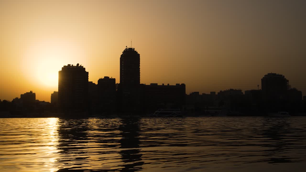 puesta de sol dorada sobre el río nilo con el fondo del horizonte de el cairo, egipto