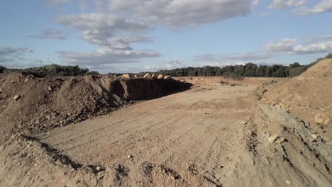 Aerial-drone-shot-reveal-a-limestone-quarry-with-winding-gravel-road-near-the-excavation-cuts